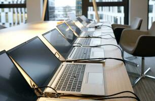 Row of laptops being prepared and set up for new employees in a company photo