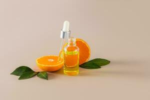 An open transparent bottle with a dropper filled with a pipette of natural self-care. Moisturizing, whitening serum based on tangerine extract. photo