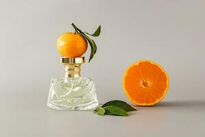 A chic bottle of women's perfume with a delicate aroma with notes of tangerine on a pastel background with ripe fruit. An original smell of freshness photo