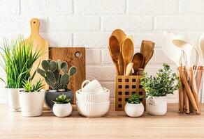 Beautiful kitchen background with set of cutting boards, wooden spoons, bowls. Front view. potted flowers. Eco-friendly kitchen photo