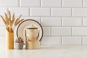 A modern kitchen background in a minimalist style with eco-friendly items on a light stone countertop by a white brick wall. A copy space. photo