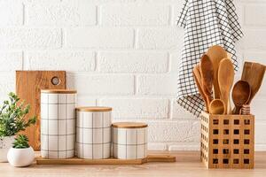 Beautiful kitchen background with set of cutting boards, wooden spoons, ceramic stylish storage jars. Front view. Eco-friendly kitchen photo