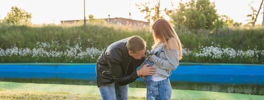 Happy smiling future parents on the walk in autumn park photo