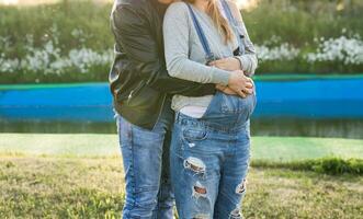 Happy smiling future parents on the walk in autumn park photo