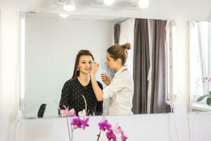 Stylist doing make up for beautiful girl photo