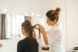 Hairdresser doing haircut for women in hairdressing salon. Concept of fashion and beauty. Positive emotion. photo