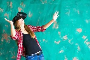 Happy woman getting experience using VR-headset glasses of virtual reality much gesticulating hands photo