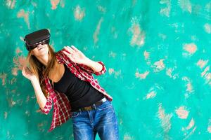 Young woman getting experience using VR-headset glasses of virtual reality much gesticulating hands photo