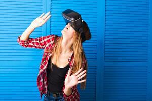 Young woman getting experience using VR-headset glasses of virtual reality much gesticulating hands photo