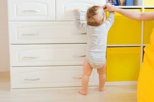 little boy first steps with the help of mother photo