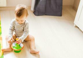 baby boy playing with toy indoors at home photo