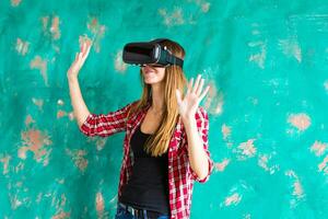 Happy woman getting experience using VR-headset glasses of virtual reality much gesticulating hands photo