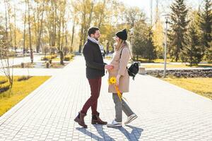 Happy pregnant woman and her husband in the park photo