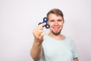 young man playing with a fidget spinner, focus on spinner. photo