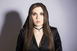 Gorgeous brunette with dark makeup. Halloween witch in studio photo