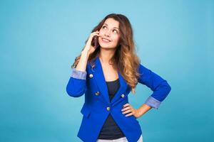 Woman talking on her cell phone over a blue background photo