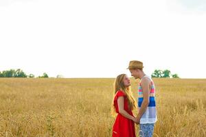 young couple in the wheat field. Summer or autumn season, copy space photo