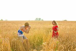 photographer with camera taking picture of young beautiful woman in the field. photo