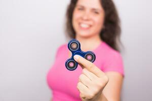 young woman playing with a fidget spinner, focus on spinner. photo