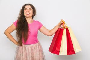 Portrait of young happy smiling woman with shopping bags, over white background. Purchase, sale and people concept photo