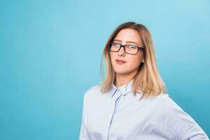 Young woman in glasses on blue background photo