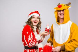 Happy young woman in santa claus hat and man in carnival costume of deer. Fun, holiday, joke and christmas concept photo