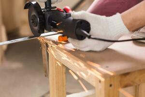 Worker Using Angle Grinder in Factory and throwing sparks. photo