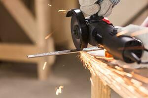 cutting metal with angle grinder, sparks from the disk. photo