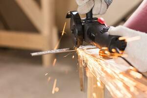 trabajador utilizando ángulo amoladora en fábrica y lanzamiento chispas. foto