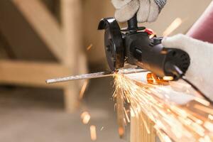 cutting metal with angle grinder, sparks from the disk. photo