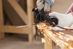 Heavy industry worker cutting steel with angle grinder photo