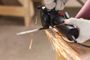 cutting metal with angle grinder, sparks from the disk. photo