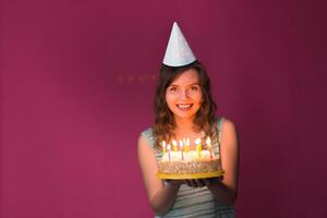 Portrait of pretty girl holding birthday cake photo