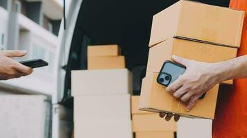 Fast and reliable service. Cheerful young delivery man giving a cardboard box to young woman while standing at the entrance of her apartment video