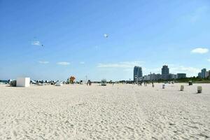 a beach with people on it and a city in the background photo