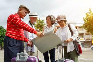 Group of senior tourist are looking at city maps to find tourist attractions on sun flare and blurred background. photo