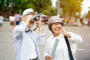 Closeup American senior tourist man take a photo in the city with his tour guide on sun flare and blurred background