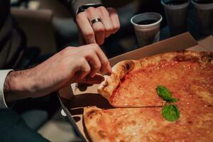 a man is cutting a pizza into pieces photo