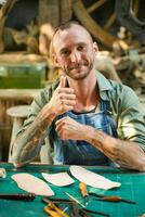 Closeup handsome craftsman acting thumbs up in his workplace photo