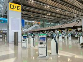 bangkok, th, 2022 - yo cheque en máquina a suvarnabhumi internacional aeropuerto. yo cheque en máquina Ayudar pasajeros de varios aerolíneas salvar hora a cola a cheque en el encimera. foto