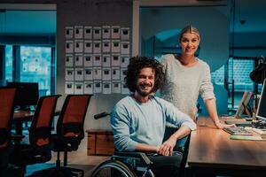 a man and woman in a wheelchair in an office photo