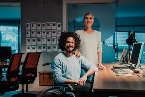 a man and woman in a wheelchair in an office photo