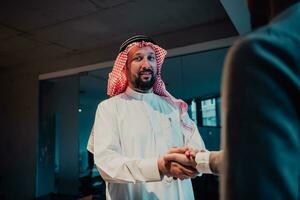 Middle eastern man shaking hands in an office photo