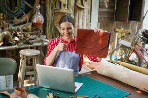 Closeup vendors show products, leather bags to customers in the live broadcast. Sell products online concepts. photo