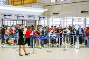 Bangkok, TH, 2018 - Many Chinese tourists waiting for check-in front of airline counter in the airport to return to the country after traveling to Thailand on Chinese New Year. photo