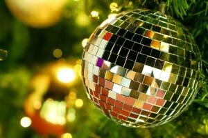 de cerca cristal pelotas decorado en pino árbol en Navidad noche con borroso antecedentes y bokeh de Navidad Encendiendo. foto