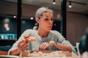 a woman eating pizza in the office photo