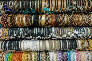 many different types of bracelets are stacked together photo