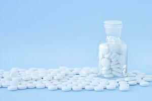 Medicine background with bottle of white pills photo