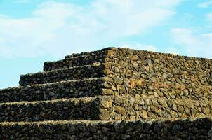 a stone pyramid with a blue sky in the background photo